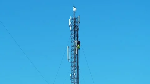 Two workmen on cell tower. Repairmen install new cable and equipment Stock Footage 321971290
