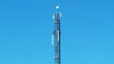 Two workmen on cell tower. Repairmen install new cable and equipment Stock Footage 323867414