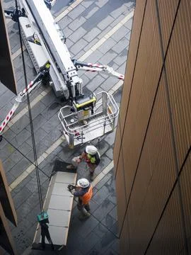 Two workmen preparing hoisting operation of a building panel Stock Photos