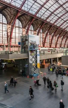 Two workmen on scaffold platform high above the busy station hall in Antwerp Foto stock