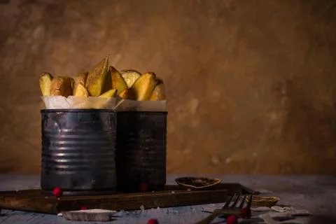 Two worn cans with fried potato stripes on cutting board Stock Photos