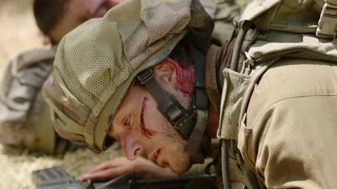 Two wounded soldiers lying on the ground in a hopeless situation talking Stock Footage 169262479