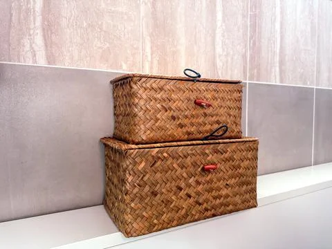 Two woven storage baskets placed neatly on a shelf in a modern bathroom Stock Photos