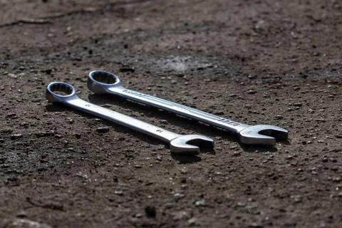 Two Wrenches Rest on a Dusty Surface, Showing Signs of Use and Wear in a Si.. Foto stock