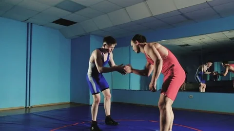 Two wrestlers Greco-Roman wrestling on the blue background slow mo Stock Footage