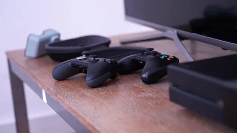 Two Xbox One videogame controllers and console on a table, medium shot Stock Footage 151924365