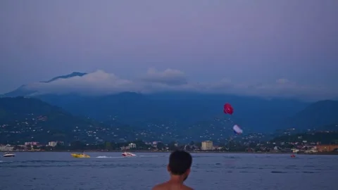 Two yachts are sailing along the sea bay, with a pair of parasails flying behind Видео 285447215