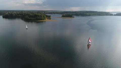 Two yachts floats on water surface in the lake. Landscape with sailing yachts Stock Footage 104708551