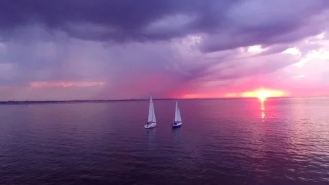 Two yachts at sunset on the high seas in a romantic dream trip.Pink sky. Stock Footage 73029494