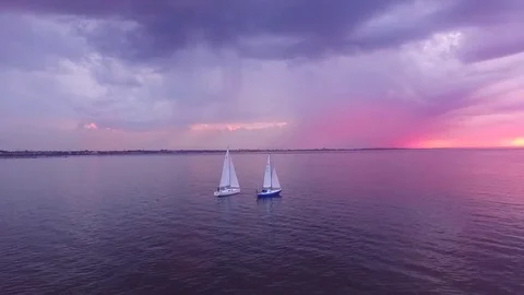 Two yachts at sunset on the high seas in a romantic dream trip.Pink sky. Stock Footage 73029585