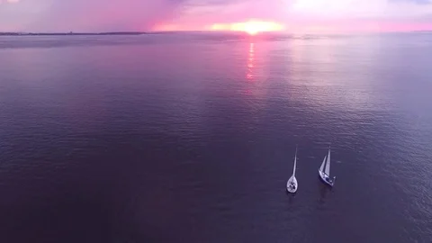 Two yachts at sunset on the high seas in a romantic dream trip.Pink sky. Stock Footage 73029668
