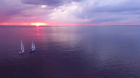 Two yachts at sunset on the high seas in a romantic dream trip.Pink sky. Stock Footage 73029784