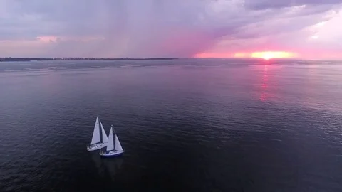 Two yachts at sunset on the high seas in a romantic dream trip.Pink sky. Stock Footage 73029871