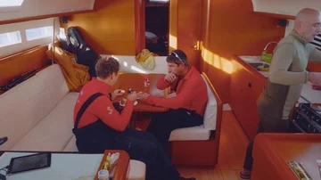 Two yachtsmen have snacks in cabin of sailing yacht Stock Footage 86081370