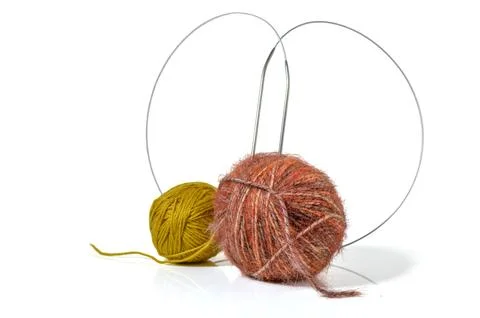 Two yarn balls in rusty orange and mustard yellow with circular knitting ne.. 库存照片