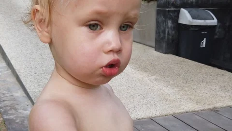  a two year old blond boy with a serious face. close up, slow motion.  Stock Footage 104848998