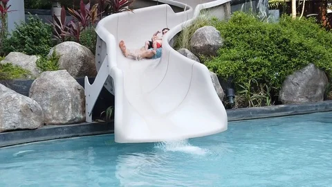 Two-year-old blond boy with his father  fun down the water slide  Stock Footage 105053068