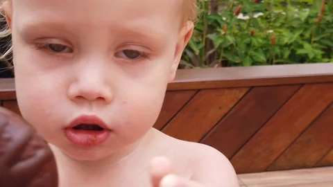 Two year old blond boy sucks a finger. close up, slow motion. Stock Footage 105594601