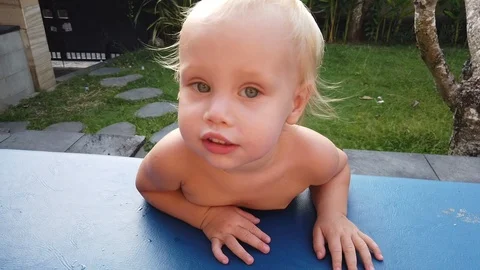 Two-year-old blond boy shakes his head in different directions, the movement of  Stock Footage 107859957
