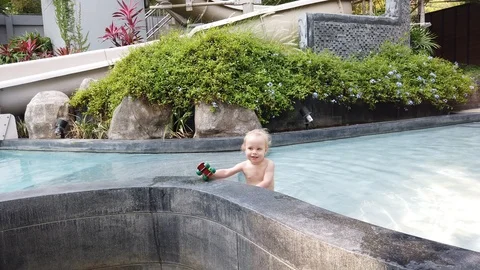 Two year old blond child playing with a toy while in the pool. Vidéo 104702009