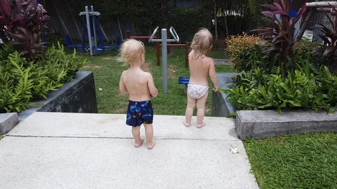A two-year-old blonde and a two-year-old boy turned away and stood Stock Footage 105004650