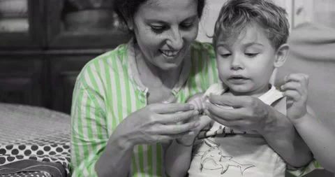 A two-year-old boy and his aunt are playing with a plaster. Stock Footage 143114148