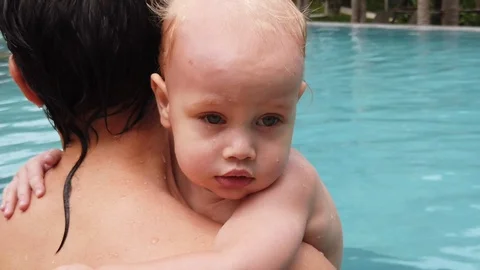 Two-year-old boy in the arms of his father in the pool Stock Footage 105596420