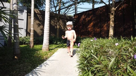 A two-year-old boy in a cap with a serious face goes to a meeting. Stock Footage 105052932
