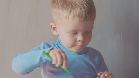 Two year old boy is drawing with marker at album 스톡 동영상 108045230