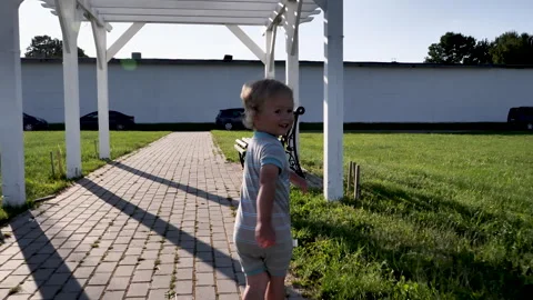 A two year old boy jogging for fun and running on track.  running under pergola Vídeos de archivo 273864797