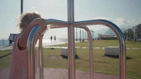 Two-year-old boy kid in the spring on the playground rides on the carousel Stock Footage 244791930