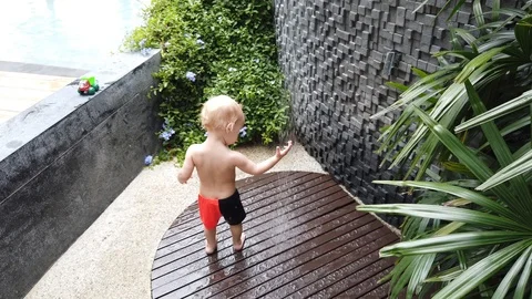 Two year old boy playing under the shower with a toy. Stock Footage 104651999