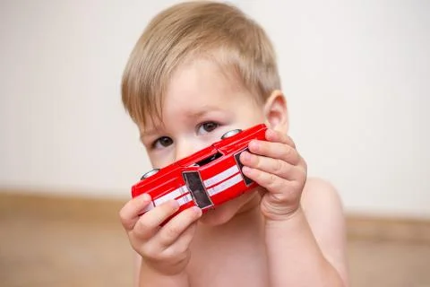 Two year old boy playing with a toy car Stock Photos
