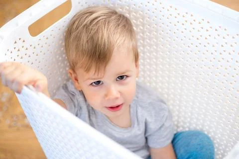 Two year old boy sitting in a box Stock Photos