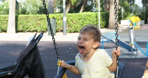 A two-year-old boy smiles while on a swing. Stock Footage 143113298