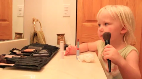 Two year old brushes on cheek color Stock Footage 41651565