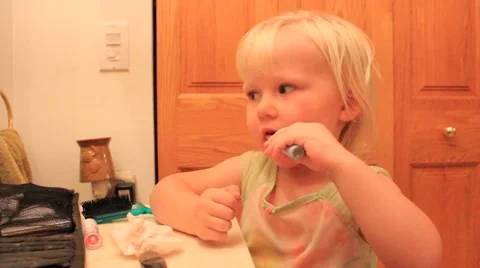 Two year old carefully applies lipstick to bottom lip Stock Footage 41651971