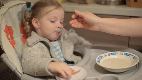 Two year old child eating porridge Stock Footage 81630464