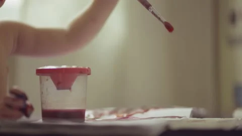 Two-year-old child indulges in and paints with watercolors Stock Footage 153548546