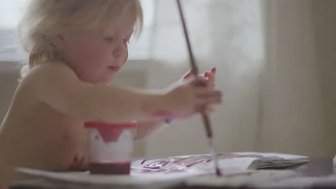 Two-year-old child indulges in and paints with watercolors Stock Footage 153549933