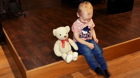 A two-year-old child plays with a teddy bear. Stock Footage 103090346