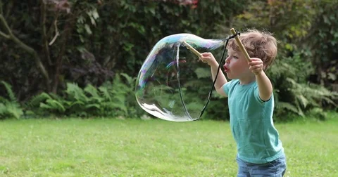 Two year old making giant bubbles sideview close up Stock Footage 72631665