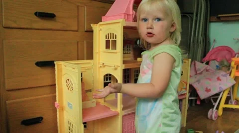 Two year old talks to camera while playing dollhouse Stock Footage 41652072
