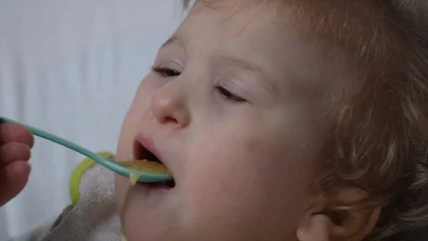 Two years old boy with cerebral palsy is fed by his mother at home. Special need Stock Footage 122614426
