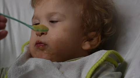 Two years old boy with cerebral palsy is fed by his mother at home. Special need Stock Footage 122614463