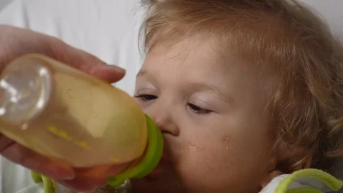 Two years old boy with cerebral palsy drinks tea from the bottle  Stock Footage 122620677