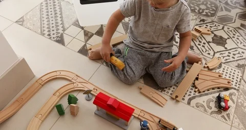 Two years old boy plays with wooden railroad Stock Footage 94606383