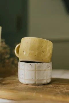 Two yellow and white ceramic cups are stacked on top of each other Foto stock