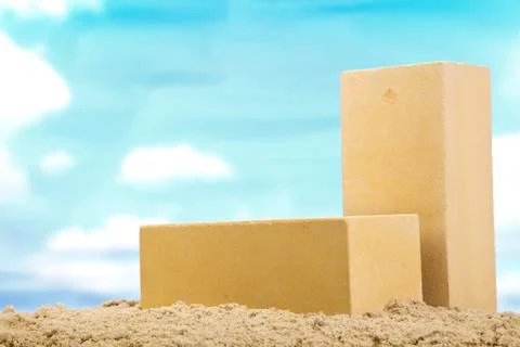 Two yellow ceramic bricks on the sand at the blue sky background Stock Photos