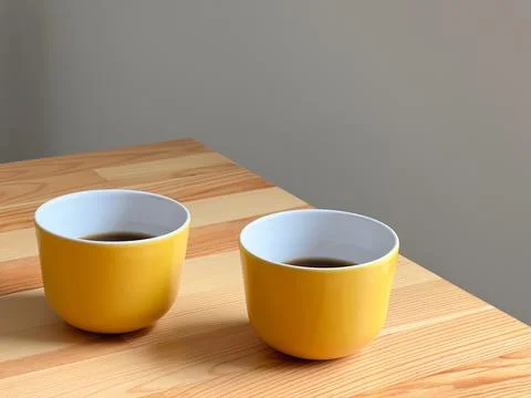 Two yellow coffee cups on the table Stock Photos
